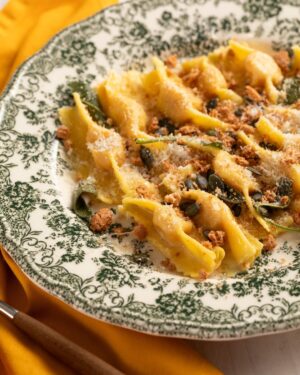 Ludovica Gargari Instagram - 🍝Il piatto vincente di... @giacomogentili_ , atleta della nazionale italiana di canottaggio, campione mondiale, europeo e argento olimpico🏅😍! Tortelli con zucca, un piatto tradizionale unico!🤤 Ps: anche se la zucca non è di stagione, per noi la tradizione vince su tutto🧡🍽️ @lulugargari @giallozafferano 

Ingredienti:
Farina 0 360 g
Uova 4
Zucca delica 500 g
Mostarda mantovana di mele 50 g
Parmigiano Reggiano DOP 50 g
Amaretti 25 g
Scorza di limone ½
Noce moscata q.b.
Sale fino q.b.
Pepe nero q.b.
Burro q.b.
Salvia q.b.
Formaggio grattuggiato q.b.
Amaretti secchi q.b.
Semi di zucca sgusciati q.b.

Pulite la zucca eliminando la buccia, e ricavate dei pezzi della stessa grandezza così da uniformare la cottura. Disponetela su una leccarda foderata con carta forno e cuocete in forno statico preriscaldato a 170° per circa 20-30 minuti. Una volta cotta, schiacciatela ancora calda con uno schiacciapatate e aggiungete gli amaretti ridotti in polvere. Unite la mostarda tritata, il formaggio grattugiato e la scorza di limone. Infine, aromatizzate con noce moscata, sale e pepe. Mescolate fino ad ottenere un composto asciutto e compatto. Versate la farina su una spianatoia e formate un buco al centro, poi versate le uova leggermente sbattute e un pizzico di sale. Iniziate a raccogliere la farina dai lati con la forchetta e a portarla verso il centro. Quando il composto inizierà a diventare più consistente, continuate ad impastare per circa 5 minuti. Formate un panetto, avvolgetelo nella pellicola e fate riposare in frigorifero per 30 minuti. Appiattite il panetto con le mani, infarinatelo e passatelo nella macchina tirapasta per ottenere una sfoglia sottile passandola ripetutamente. Dividete la sfoglia in quadrati di 5-6 cm di lato utilizzando una rotella dentellata. Farcite con un po' di ripieno. Richiudete i tortelli ripiegandoli a metà e premete bene con le dita lungo i lati per sigillarli. Portate a bollore una pentola, mentre in una padella fate sciogliere il burro con qualche foglia di salvia.

#giallozafferano #gz #atleti #giacomogentili #tortelli #zucca