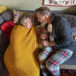 Stina Wollter Instagram - Vi har Bröllopsdag idag. @olsmick å jag.
Vi gifte oss 2018 efter 23 års förlovning. 
Tiden är vår tredje part i detta äktenskap. 
Tiden som runnit genom oss, tiden som nu är att vi delat halva livet med varandra. Tiden som att vi bär den andres historia. Tiden som att den som är kvar är förunderligt dyrbar, och den är vår. 
Micke har det vackraste morgonhumöret i världen och är lättglad över små vardagliga saker, tex mig, smörgåsar och kaffesorten Blond. Vi delar inte bara kärleken till varandra utan den expanderar och omsluter självklart våra barn och vårt barnbarn men också våra vänner och familjemedlemmar som delat hela eller delar av vår tid. Och som hängt med i toppar och dalar. 
Jag minns när min vän Maria gifte sig, alla gäster i kyrkan gick fram med små tagetesblomhuvuden och lade runt parets fötter i en hjärtform. En fin bild av att kärleken även när den huserad av två, vårdas och hålls av många fler. 
Jag känner mig lite fjantig som delar massa bilder på oss men det var roligt att bläddra runt och titta i våra album. 
Hälsningar i kärlek från oss. Som inte har krisat på ett helt halvår tror jag ta mig fan. Rekord. För relationer är ett jäkla stolleprov egentligen men man gör det ändå.