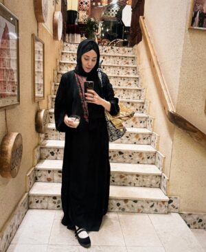 Fatima AlBanawi Instagram - تأملاتي هذه الفترة من خلال صور التقطتها:
١. شمّرنا الأكمام - أحس إني كنت ظالمة الملوخية الناشفة إلى أن دقتها في المدينة!

٢. موديرنيتي ومينيماليزم في صورة - علمونا أن الحداثة والشكل العصري في الغالب شكلهم غربي، ولكن لو بس نوقف عند الزبادي والدقّة والشريك في لحظة فكّ الريق في الحرم ونتأمّل تفاصيل البساطة والتعقيد والصحة والوعي والتقليد والعصرية اللي فيها.

٣. يا الله على حال الإنسان - فرحتي أن جدّو قدر يحفظ ويقول ويعيد جملة من غير ما ينساها بعد ثواني أعظم وقعًا عليّة من فرحتي بنطق طفل ما بأول كلمة في حياته!

٤. أحد مصادر دعائي هذه الفترة - الحب والإخلاص والمودة والرحمة اللي أشوفهم بين ستو وجدّو. الله يزيدكم لو انتو فيها والله يهبكم منها لو محرومين.

٥. الله حقّ! الله قريب! - لو أنك بلد مظلوم وشعب مظلوم وسرد مظلوم، بس هذه الحشود وقفت مع بعض وأمَّنَت وآمنت وراء دعاء الشيخ في لحظة استجابة، ايش تحس حتكون النتيجة؟ إذا قال كن فيكون. آمين.

٦. ما في أغلى وأغنى من هذا الشعور - الساعة ٤:٣٠ فجرًا، عند باب عثمان بن عفّان (٢٥) وفي يدّك شاورما من الـسلطان أفوكادو وتمرتين وموية، وفي صحبتك ناس رايقة، وعلى خدّك برد المدينة، وعلى خشمك حمرة الترجّي والدعاء، وكلكم على بعضكم في بيت الحبيب (ص).

٧. أنت من فريق ستّي وستّك ولا فريق طبق طبقنا؟ - (١) ستي وستك في الحمام قامت ستي ضربت ستك، تقدر ستك تضرب ستي زي ما ستي ضربت ستك في الحمام. (٢) طبق طبقنا ضرب طبق طبقكم يعرف طبق طبقكم يضرب طبق طبقنا زي ما طبق طبقنا ضرب طبق طبقكم.

٨. ليش ما حد عمره جاب بسيرة هذه النقطة!؟ - كلمة حيوان ذكرت مرة واحدة في القرآن فقط (سورة العنكبوت) وكان معناها (الحياة الحقيقية الدائمة في الآخرة). أما كلمة الحيوان بمعناها المتداول بيننا، فجاءت في القرآن كالـ (دابة) (الأنعام) (الطيبات)…إلخ 

٩. أحد نماذج سُفَر الحرم

١٠. أحد تصورات أزياء الحرم

١١. صورة نادرة لحاجية أمام مرآة مبللة

١٢. عائلة تصلي الجماعة في المنزل 

١٣. أكثر المنتجات مبيعًا في الموسم

١٤. ابتسامة الختام، دمتم سالمين