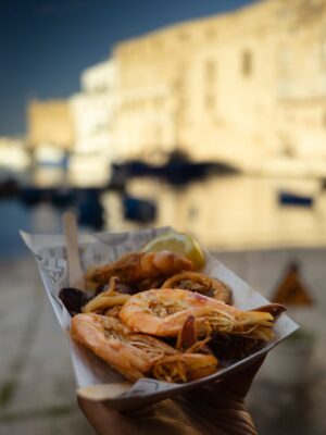 Rebecca Roy Instagram - 📍Monopoli, Puglia
our favourite coastal gem in Italy you’ve probably never heard of (but should definitely visit!)
Here’s what we loved and what you can’t miss:

	1.	Wander the old town – cobbled alleys, baroque churches, and pastel buildings that look straight out of a painting.
	2.	Visit the Cathedral of Maria Santissima della Madia – both the façade and the interiors left us speechless.
	3.	Catch golden hour by the port – the blue fishing boats and warm light? Pure magic.
	4.	Snack on fresh seafood from a street-side kiosk – crispy, salty, and unforgettable.
	5.	Stop by Salumeria Gustavo – a cozy spot where we had some of the best cured meats and local snacks.
	6.	If you’re lucky, stumble into a street performance or local parade – we did, and it was pure joy!

Monopoli may not be on every tourist’s radar, but that’s what makes it even more special.
Just the two of us, the sea breeze, and a town that made us fall in love all over again! 
Share it your apulian travel partner! 

Travel by @gtholidays.in 

#chennaiinfluencer #italytravel #monopoli #coupletravel #italysummer #coupleinfluencer #indianblogger #italytrip #travelbloggers #puglia #puglialovers