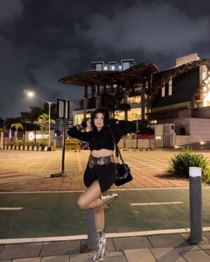 Simran D Sharma Instagram - City lights, silver boots, and no rules…. 🪩
.
.
#FashionInspo #OOTD #StyleGoals #TrendAlert #StreetStyle #InstaFashion #BootGameStrong #StatementLook #AllBlackFit #SkirtStyle #BoldFashion #ChicAndSassy