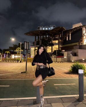 Simran D Sharma Instagram - City lights, silver boots, and no rules…. 🪩
.
.
#FashionInspo #OOTD #StyleGoals #TrendAlert #StreetStyle #InstaFashion #BootGameStrong #StatementLook #AllBlackFit #SkirtStyle #BoldFashion #ChicAndSassy