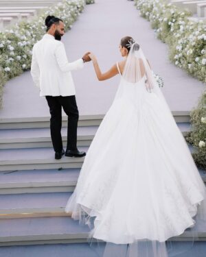 Amina Khalil Instagram - On the most important day of her life, #AminaKhalil stepped into her forever, surrounded by towering palms and a sea of white. For this deeply personal celebration, she wears a custom creation by Maison Yeya: a modern interpretation of a timeless princess silhouette. Designed by Yasmine Yeya, the gown sculpted her figure before cascading into voluminous layers of triple silk gazar, delicately embroidered at the hem. Captured exclusively for Vogue Arabia, the first glimpse of an Egyptian actress revealing a modern bridal vision.

في أهم يومٍ في حياتها، أطلت أمينة خليل كحلمٍ محاطةً بسحر النخيل الباسق ونقاء الأبيض الناصع. لحفلها زفافها، تألقت أمينة بفستان من "ميزون يحيى"، صُمم خصيصًا ليجعل منها أميرةً عصريةً خالدة. احتضن الفستان، الذي أبدعت ياسمين يحيى بتصميمه، قوامها قبل أن يتدفق على طبقاتٍ شاسعة من الغازار الحريري، مطرزًا بدقةٍ عند الأطراف. وفي صورٍ حصرية لمجلة ڤوغ العربية، تلوح أول لمحةٍ لممثلةٍ مصريةٍ تكشف رؤيةٍ عصريةٍ لفساتين الزفاف.

Photography: @lamismagdy 
Stylist: @mohamedashraff
Makeup: @Itsnohathemua
Hair: @kimisafadi 
Dress: @maisonyeya 
Shoes: @jimmychoo 
Jewellery: @elkadyjewelry 
Event planning: @vertex.events 

#VogueArabia