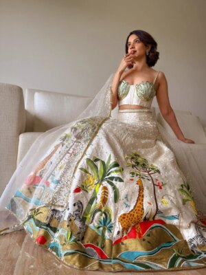 Anandita Pagnis Instagram - Step into our whimsical world of hand-painted giraffes, zebras, and banana trees, amidst buzzing fireflies and majestic cockatoos. Our Golden Earth Hand-painted Lehenga Set brings the Jungle Book to life on rich raw silk, with metallic gold tones and intricate embroidery that shines like the night sky. Every detail is a brushstroke of magic, every thread a whisper of wonder 🦓🌴🦒🌿🏝️🪺🔱

[World of Anush, Bespoke, Lehenga Set, Corset, Floral, Hand embroidery, Hand Painting] 

#worldofanush #bespoke #lehenga #corset #instagram #fyp