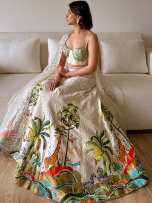 Anandita Pagnis Instagram - Step into our whimsical world of hand-painted giraffes, zebras, and banana trees, amidst buzzing fireflies and majestic cockatoos. Our Golden Earth Hand-painted Lehenga Set brings the Jungle Book to life on rich raw silk, with metallic gold tones and intricate embroidery that shines like the night sky. Every detail is a brushstroke of magic, every thread a whisper of wonder 🦓🌴🦒🌿🏝️🪺🔱

[World of Anush, Bespoke, Lehenga Set, Corset, Floral, Hand embroidery, Hand Painting] 

#worldofanush #bespoke #lehenga #corset #instagram #fyp
