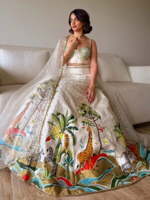 Anandita Pagnis Instagram - Step into our whimsical world of hand-painted giraffes, zebras, and banana trees, amidst buzzing fireflies and majestic cockatoos. Our Golden Earth Hand-painted Lehenga Set brings the Jungle Book to life on rich raw silk, with metallic gold tones and intricate embroidery that shines like the night sky. Every detail is a brushstroke of magic, every thread a whisper of wonder 🦓🌴🦒🌿🏝️🪺🔱

[World of Anush, Bespoke, Lehenga Set, Corset, Floral, Hand embroidery, Hand Painting] 

#worldofanush #bespoke #lehenga #corset #instagram #fyp