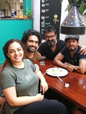 Nithya Menen Instagram - There are some moments (that come rarely) when I feel very nourished by a movie. Simply because it was real cinema… and I could engage the artist in me. I could really do the work that I was always meant to do , but get to do so little of :)
One of those movies is ‘Kolaambi’ directed by @tkrajeevkumar . And it is, to date, one of the few films I’ve done that I know will stand the test of time. Because art lives on and never gets old, and never changes. I still remember well, the day Rajeev sir came to see me in Bangalore at my home to talk to me about this film. It sounded like a real film. Like it had a beating heart. I didn’t need even a moment to think about it. 
And as I expected, I loved working on the film and the people there - The ‘Agrahaaram’ we shot in - where the people would greet us every morning as they went about their everyday routine. We were now just a part of their routine and they would treat us so casually- which I LOVED! No unnecessary intrusion, attention, excitement regarding films or actors or  shooting. What a dream that was- to go about our work normally. We made sure we were as respectful as possible too- keeping silence, eating vegetarian food and keeping the place clean . 
The spunky ‘Paati’ who kept me company while I was waiting in-between shots. She shared her home, her stories and most of all- her AC with us :D
After a week, I found our Line Producer Sujit Soman sitting on her dining table at the far end of her house, eating his meals. They let us do that. They shared everything. 
The river at the end of the road to the Agrahaaram that I would walk up to whenever I had some time . It was a dream to be so close to nature which, truth be told, is the thing I enjoy most. 
And our communal meals in that same restaurant in Fort Cochin! @iamsijoyvarghese @siddharth2121 @r_varman_ and I . We would put all the food in the middle and eat straight off the same bowl. I miss that very much. I felt like myself & I took away something big from it, thanks to Sijoy :)
I hope I have more of this in the days and years to come - these kind of films and these kind of people 🌺
@renji_panicker @rohinimolleti @dileeshpothan @resulpookutty @sabu_cyril