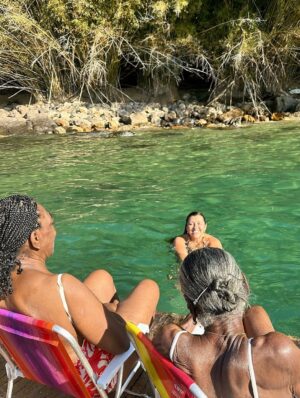 Regina Casé Instagram - Olha que delícia essa batedeira no pôr do sol na Ilha Grande, genteee!!!

Quem vê esse cara assim não imagina quantas outras coisas ele sabe fazer tão bem. Cuidar da avó, cuidar da mãe, das tias, da família todinha...

É muito impressionante a criação que esse menino teve, a educação que ele recebeu de todas essas mulheres... É lindo demais ver as duas coisas convivendo juntas. 

A batedeira e a trezena de Santo Antônio.

A batedeira e ele honrando sua ancestralidade no Candomblé da sua tia.

A batedeira e ele trabalhando a vida toda com sua mãe, ajudando ela no seu tabuleiro de acarajé.

A batedeira e o cuidado que ele teve com a Preta e que agora tem comigo, a educação esmerada.

Foi uma maravilha receber vocês! 

Já estou com saudade do fim de semana que passou, mas já já a gente vai tá juntinho de novo na Bahia. 

Não canso de agradecer a minha Pretinha. Obrigada, @pretagil , por ter me dado essa família incrível de presente! Quando a gente tá junto, só falamos de você, com amor e saudade...

Dona Jandira, Dona Rosa, Nêga, Cabocla, Letícia e Danrlei te amam tanto, que é perto deles que eu gosto de estar, sempre honrando sua memória! ❤️
