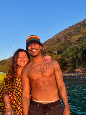 Regina Casé Instagram - Olha que delícia essa batedeira no pôr do sol na Ilha Grande, genteee!!!

Quem vê esse cara assim não imagina quantas outras coisas ele sabe fazer tão bem. Cuidar da avó, cuidar da mãe, das tias, da família todinha...

É muito impressionante a criação que esse menino teve, a educação que ele recebeu de todas essas mulheres... É lindo demais ver as duas coisas convivendo juntas. 

A batedeira e a trezena de Santo Antônio.

A batedeira e ele honrando sua ancestralidade no Candomblé da sua tia.

A batedeira e ele trabalhando a vida toda com sua mãe, ajudando ela no seu tabuleiro de acarajé.

A batedeira e o cuidado que ele teve com a Preta e que agora tem comigo, a educação esmerada.

Foi uma maravilha receber vocês! 

Já estou com saudade do fim de semana que passou, mas já já a gente vai tá juntinho de novo na Bahia. 

Não canso de agradecer a minha Pretinha. Obrigada, @pretagil , por ter me dado essa família incrível de presente! Quando a gente tá junto, só falamos de você, com amor e saudade...

Dona Jandira, Dona Rosa, Nêga, Cabocla, Letícia e Danrlei te amam tanto, que é perto deles que eu gosto de estar, sempre honrando sua memória! ❤️