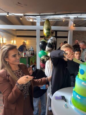 Monique Westenberg Instagram - Part I. 
Gisteren was Dré jarig en dat vierden we in de tuin.
Waarom doe je dat eind oktober, zou je denken!? Omdat we de afgelopen jaren altijd prachtig weer op deze dag hadden. Toen huurden wij een zaaltje, maar stond alle visite, puntje bij paaltje,  buiten. Dit jaar was dat anders 😅.

Gelukkig werden we gered door @tentworx.nl, waardoor het niet alleen heel gezellig stond, maar we ook droog stonden. Dit heb ik gezellig laten aankleden met ballonnen door @deballonnenkoning. In plaats van een luchtkussen kwam de @gamebus.nl, en dat was een groot succes voor zowel de jongens als de meisjes.

Voor de kleintjes had ik een gezellige knutseltafel droog gezet. Ik kom uit een ondernemende horecafamilie die veel zelf in huis heeft. Mijn vader kwam met zijn bar, m’n broer met een suikerspinmachine en statafels, en onze Italiaanse vriend kwam lekker pizza’s maken.

Lieve Katie van @the.steakclub kwam ter plekke heerlijke sushi en taco’s klaarmaken. En wat ik vooral heel fijn vond, is dat de twee meiden van @deregeltantesnl veel voor mij uit handen namen, zodat ik ook nog wat kon kletsen met de visite in plaats van alleen maar bezig te zijn met van alles en nog wat…je kent het wel.

Aan het eind van de dag liep ik alsnog met m’n tong op de grond, maar het scheelde een hele hoop dat deze vier extra handen er waren met zoveel visite.

Als verrassing kwam ‘papa’ ook nog even langs voor zijn show. Dat was echt een geluksmomentje voor Dré. Het was een supergezellige dag!! 🥳