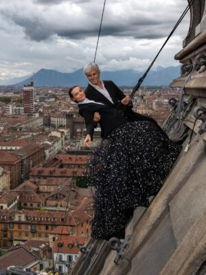Kasia Smutniak Instagram - K - Scrivi tu.
D - No scrivi tu, dai, è più carino.
K - Ma che vuol dire carino? Dillo che non ti va
D - Ma queste cose le sai fare meglio, e poi sei più personaggio…
K - Insomma non ti va.
D - Non saprei cosa scrivere.
K - Scrivi com’è che hai detto di sì senza pensarci due volte e soprattutto senza chiedermelo.
E poi hai detto “Ah sì, ci appendiamo alla Mole”. “In che senso?” ho chiesto.
“Ma sì! Quando ci ricapita più? Con Riccardo?” “Riccardo chi??” “Ghilardi.
Ci fa delle foto, non so, cose sue. Ma che ci frega delle foto, l’importante è che ci appendiamo“
“Ah quindi non sai nemmeno perché dovremmo appenderci a questa Mole??”
“Non mi ricordo bene” “Comunque non mi va che dici di sì al posto mio” “Avresti detto di sì?”
“Certo!” “E allora?”
“E allora va bene, ci appendiamo alla Mole, ci mancherebbe, però la prossima volta me lo chiedi!”
“La prossima volta che qualcuno mi chiede se ci va di appenderci alla Mole Antonelliana,
166 metri di altezza, per motivi poco chiari, giuro che te lo chiedo“. - così hai detto e fine del siparietto.
E poi racconti che ci abbiamo messo più di un anno, un tentativo andato male per il maltempo,
Riccardo che si è allenato per mesi, le foto assurde che ci mandava.
Il gruppo di arrampicatori che hanno studiato come fare tutto in sicurezza,
l’abito d’alta moda di Armani tagliato per mettere l’imbracatura sotto, e tu che ballavi il tip tap sulla cupola, felice come un bambino.

D - Ecco, lo vedi che sai tutto? Scrivilo tu
K - No
D - E allora non scriviamo niente

— Kasia Smutniak e Domenico Procacci 

“Piano sequenza. La Mole”, la mostra fotografica di Riccardo Ghilardi, dedicata ai 25 anni del Museo Nazionale del Cinema, 
Gallerie d’Italia di Torino .