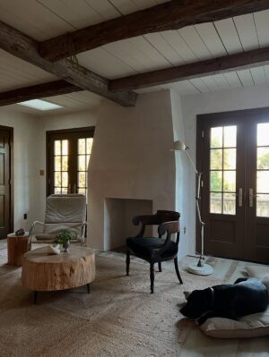 Lauren Liess Instagram - The “Whalerman’s Watch” beach cottage is almost finished just in time for the holidays! 🐳 So thankful for this chill time with the family. Sending love to you and yours this Thanksgiving! 

The design details: 
Leftover beams from the Meadow give the place those old scrap wood Outer Banks vibes with a little bit o’ those old English Lost Colony Roots. The original houses around here were made from leftover scrap wood from barns, shipwrecks etc. Still working on things like installing countertops and lighting.

Stucco walls, planked board ceilings, painted old floorboards mixed with brick and some existing furnishings (the ikea table came with the house & we had most everything in our barn!) and a couple of new pieces (the Meadow sofa from my collection with @taylorkingfurniture   an antique Swedish 1872-painted chest) have made this place into a relaxed, cozy, and flop-able beach pad. Loving it in the off-season with candles, kids and pups.  The whole renovation is featured in our “Saving Lost Cottages of the Outer Banks” video series. 🤍🌊