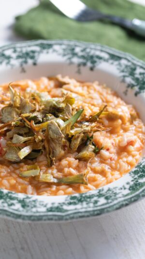 Ludovica Gargari Instagram - Elegante, gustoso, ricco di gusto...😋 Questo risotto con gamberi e carciofi con bisque veloce di @lulugargari , nostra resident chef creator è spettacolare!😍❤ @giallozafferano

Ingredienti:
Riso Carnaroli 320 g
Gamberi rossi (da pulire) 1 kg
Concentrato di pomodoro 40 g
Brodo vegetale 500 g
Vino bianco secco 100 g
Burro 40 g
Parmigiano Reggiano DOP 40 g
Scorza di limone q.b.
Acqua 60 g

Per i carciofi:
Carciofi (da pulire) 4
Olio extravergine d’oliva 80 g
Sale fino q.b.
Pepe nero q.b.

Per mantecare:
Burro freddo 40 g
Parmigiano Reggiano DOP 40 g

Tostate il riso in una casseruola ben calda, a secco, finché i chicchi risultano lucidi. Sfumate con il vino bianco e lasciate evaporare, quindi portate a cottura aggiungendo poco alla volta il brodo vegetale (o acqua calda). Preparate la bisque veloce: sgusciate i gamberi e tenete da parte polpa, carapaci e teste. In una padella fate tostare carapaci e teste con un filo d’olio, sfumate con il vino bianco e lasciate evaporare. Unite il concentrato di pomodoro, aggiungete un po’ d’acqua (60 g) e fate cuocere per circa 5 minuti. Filtrate il fondo ottenuto e aggiungetelo al riso in cottura. Pulite i carciofi, affettateli finemente e saltateli in padella con olio extravergine d’oliva fino a renderli dorati e croccanti. Uniteli al risotto insieme ai gamberi tagliati a pezzetti. Mantecate a fuoco spento con burro e Parmigiano, regolate di sale e pepe e mescolate bene. Impiattate completando con una grattugiata di scorza di limone.

#giallozafferano #gz #risotto #carciofi #gamberi