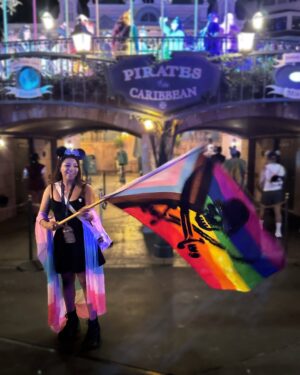 Mica Burton Instagram - the world is on fire, but hey, at least i made it to 31 as of today ✨🎂

i also got to wave around this huge gay pirate flag so honestly that’s all that matters 🩷❤️🧡💛💚🩵💜