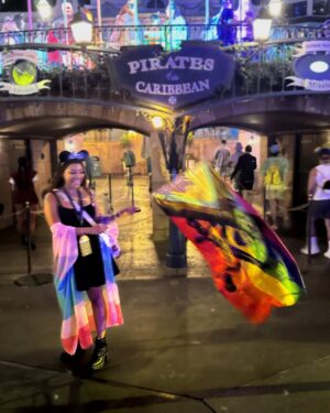 Mica Burton Instagram - the world is on fire, but hey, at least i made it to 31 as of today ✨🎂

i also got to wave around this huge gay pirate flag so honestly that’s all that matters 🩷❤️🧡💛💚🩵💜