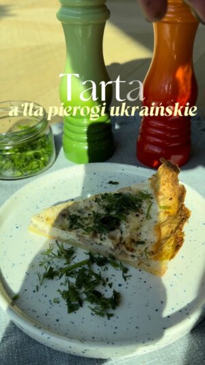 Agnieszka Sienkiewicz Instagram - Od dłuższego czasu chodzą za mną pierogi z serowo-ziemniaczanym farszem ale strasznie nie chce mi się ich lepić, więc właściwie przyśnił mi się taki pomysł na tartę. Robiłam go z drżącymi rękoma, ale jednak wyszło, więc dzielę się przepisem.
Około 0,5 kg ziemniaków (lepiej zrobić więcej, najwyżej zostaną na jutro na obiad) gotuję w osolonej wodzie do miękkości.
W międzyczasie podsmażam posiekaną w kostkę jedną średnią cebulę razem z pokrojonym boczkiem (200 g) i dodaję do niego natkę pietruszki z koperkiem lub bez. Ale pietruszka naprawdę fajnie pasuje!
Tłukę ziemniaki i robię z nich spód do tarty w wysmarowanym wcześniej grubo masłem naczyniu. Podpiekam w 200 stopniach, aż się zrumieni. Wykładam na podpieczony spód boczek z cebulą, dodaję dużo twarogu i wylewam masę jajeczną (u mnie wyszły 4 jajka i kubeczek (250 g) śmietany kwaśnej 18%).
Doprawiam solą i pieprzem (z solą bardzo ostrożnie, bo boczek jest słony) i wstawiam do piekarnika na 200 stopni, aż masa stężeje, zetnie się i zrumieni.
Na ciepło smakuje najlepiej!