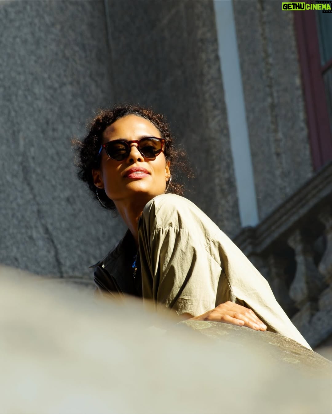 Aisha Jambo - 1.4K Likes - O Rio tem disso: transforma qualquer esquina em cenário. Dourada pelo sol, envolta pela cidade que eu tanto amo, e com @miltonbitucanascimento na cabeça, esse lindo das artes que faz aniversário hoje, uma inspiração… Entre luz, sombra e vento carioca, respiro o instante… ☀️ 🤎