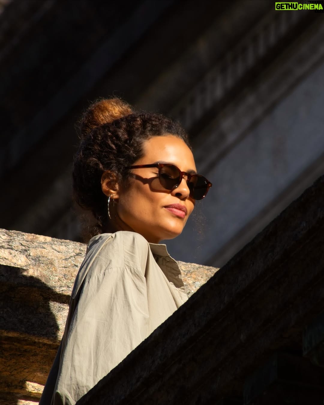 Aisha Jambo - 1.4K Likes - O Rio tem disso: transforma qualquer esquina em cenário. Dourada pelo sol, envolta pela cidade que eu tanto amo, e com @miltonbitucanascimento na cabeça, esse lindo das artes que faz aniversário hoje, uma inspiração… Entre luz, sombra e vento carioca, respiro o instante… ☀️ 🤎