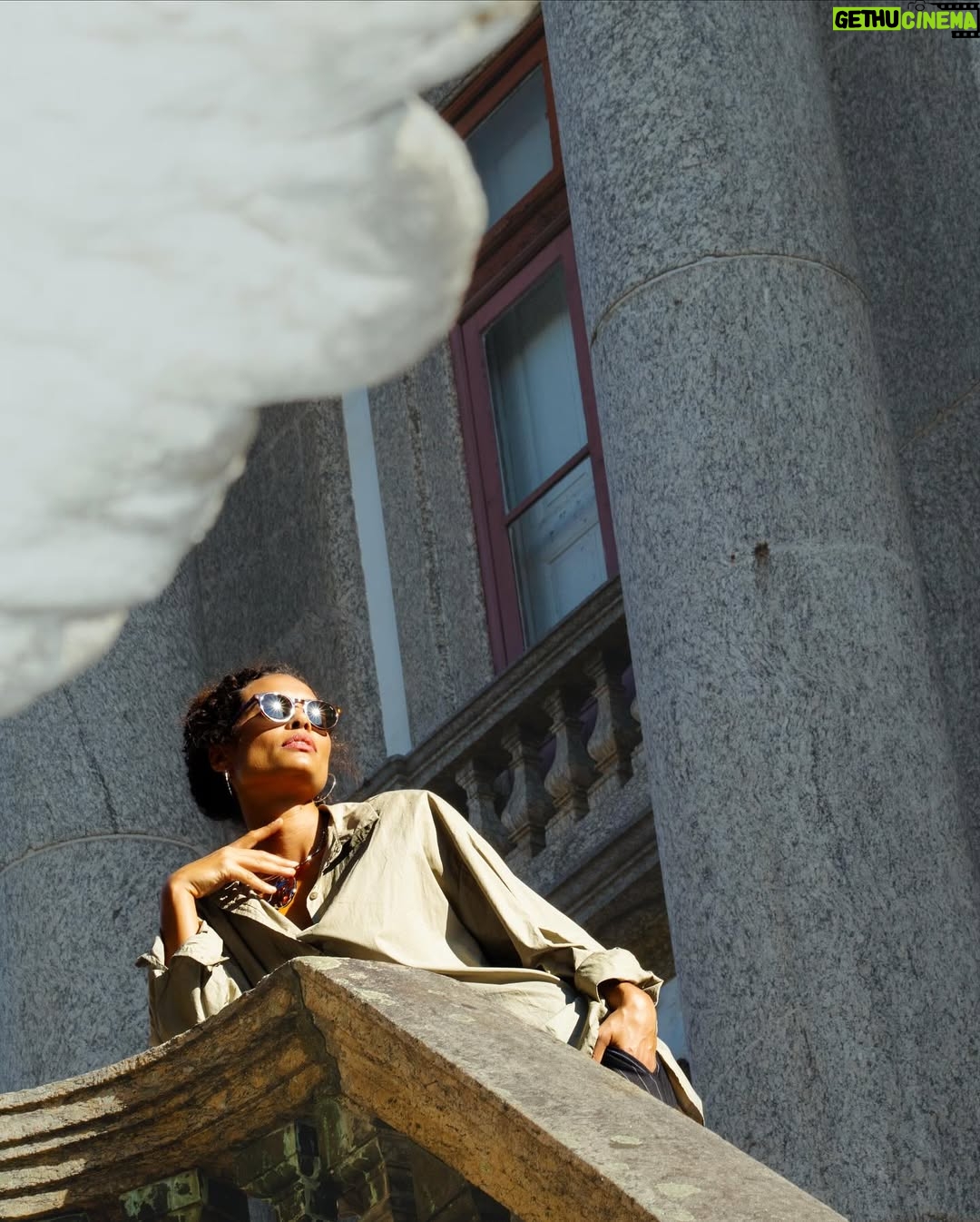 Aisha Jambo - 1.4K Likes - O Rio tem disso: transforma qualquer esquina em cenário. Dourada pelo sol, envolta pela cidade que eu tanto amo, e com @miltonbitucanascimento na cabeça, esse lindo das artes que faz aniversário hoje, uma inspiração… Entre luz, sombra e vento carioca, respiro o instante… ☀️ 🤎