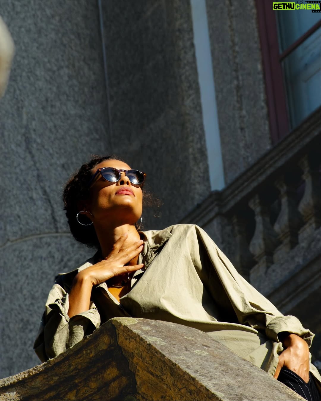 Aisha Jambo - 1.4K Likes - O Rio tem disso: transforma qualquer esquina em cenário. Dourada pelo sol, envolta pela cidade que eu tanto amo, e com @miltonbitucanascimento na cabeça, esse lindo das artes que faz aniversário hoje, uma inspiração… Entre luz, sombra e vento carioca, respiro o instante… ☀️ 🤎