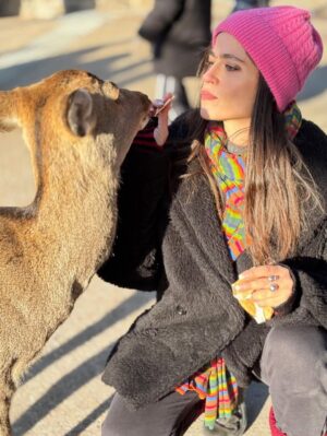 Veronica Gentili Instagram - Oggi sono stata a Nara, antica capitale del Giappone, a mezzora di treno da Kyoto e considerata la culla della cultura giapponese. 
Purtroppo però tutto questo, nella mia gerarchia, è immediatamente passato in secondo piano di fronte agli occhioni dei cervi che passeggiano liberi a spasso per il parco e che ti vengono incontro per fare amicizia ( sí lo so che vogliono le gallette di riso, di cui chiaramente mi sono subito munita, ma d’altronde in quale amicizia non è richiesto un po’ di sano do ut des?! ). 
Nel parco ci sono 1200 esemplari sparsi che se ne vanno in giro tra la gente. Tutti i giapponesi e i turisti che sono lì per visitare il Tempio Todaji, dove pregare o ammirare il Grande Buddha, finiscono irretiti da questi Bambi che scorrazzano dappertutto, finendo quasi per dimenticarsi dove stavano andando. Io poi, che ve lo dico a fare. 
La cosa fantastica è che i piccoli seduttori hanno imparato a fare l’inchino per ringraziare, quindi, se per caso tu non ti fossi già squagliato così, ti vengono incontro e si profondono in riverenze. A breve mi aspetto che imparino anche a rispondere ‘arigatou gozaimasu’ ad ogni morso di galletta. 
Dall’interno del tempio, dai suoi 15 metri di altezza, Buddha sorride sotto i baffi e aspetta che la parentesi cervi si concluda spontaneamente. 
Pare venga da qui la proverbiale calma buddhista.
