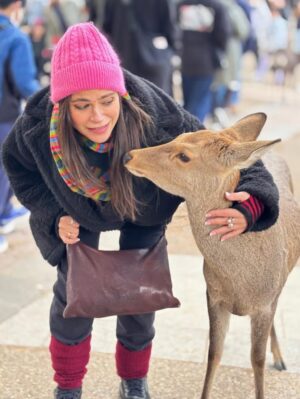 Veronica Gentili Instagram - Oggi sono stata a Nara, antica capitale del Giappone, a mezzora di treno da Kyoto e considerata la culla della cultura giapponese. 
Purtroppo però tutto questo, nella mia gerarchia, è immediatamente passato in secondo piano di fronte agli occhioni dei cervi che passeggiano liberi a spasso per il parco e che ti vengono incontro per fare amicizia ( sí lo so che vogliono le gallette di riso, di cui chiaramente mi sono subito munita, ma d’altronde in quale amicizia non è richiesto un po’ di sano do ut des?! ). 
Nel parco ci sono 1200 esemplari sparsi che se ne vanno in giro tra la gente. Tutti i giapponesi e i turisti che sono lì per visitare il Tempio Todaji, dove pregare o ammirare il Grande Buddha, finiscono irretiti da questi Bambi che scorrazzano dappertutto, finendo quasi per dimenticarsi dove stavano andando. Io poi, che ve lo dico a fare. 
La cosa fantastica è che i piccoli seduttori hanno imparato a fare l’inchino per ringraziare, quindi, se per caso tu non ti fossi già squagliato così, ti vengono incontro e si profondono in riverenze. A breve mi aspetto che imparino anche a rispondere ‘arigatou gozaimasu’ ad ogni morso di galletta. 
Dall’interno del tempio, dai suoi 15 metri di altezza, Buddha sorride sotto i baffi e aspetta che la parentesi cervi si concluda spontaneamente. 
Pare venga da qui la proverbiale calma buddhista.