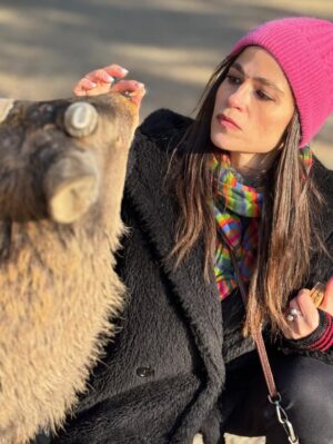 Veronica Gentili Instagram - Oggi sono stata a Nara, antica capitale del Giappone, a mezzora di treno da Kyoto e considerata la culla della cultura giapponese. 
Purtroppo però tutto questo, nella mia gerarchia, è immediatamente passato in secondo piano di fronte agli occhioni dei cervi che passeggiano liberi a spasso per il parco e che ti vengono incontro per fare amicizia ( sí lo so che vogliono le gallette di riso, di cui chiaramente mi sono subito munita, ma d’altronde in quale amicizia non è richiesto un po’ di sano do ut des?! ). 
Nel parco ci sono 1200 esemplari sparsi che se ne vanno in giro tra la gente. Tutti i giapponesi e i turisti che sono lì per visitare il Tempio Todaji, dove pregare o ammirare il Grande Buddha, finiscono irretiti da questi Bambi che scorrazzano dappertutto, finendo quasi per dimenticarsi dove stavano andando. Io poi, che ve lo dico a fare. 
La cosa fantastica è che i piccoli seduttori hanno imparato a fare l’inchino per ringraziare, quindi, se per caso tu non ti fossi già squagliato così, ti vengono incontro e si profondono in riverenze. A breve mi aspetto che imparino anche a rispondere ‘arigatou gozaimasu’ ad ogni morso di galletta. 
Dall’interno del tempio, dai suoi 15 metri di altezza, Buddha sorride sotto i baffi e aspetta che la parentesi cervi si concluda spontaneamente. 
Pare venga da qui la proverbiale calma buddhista.