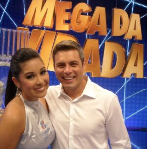 Bruna Aiiso Instagram - Durante dez anos eu fui a “Garota da Sorte”, assistente de palco das loterias da Caixa Econômica Federal. Estive ao lado de César Filho, Nadja Haddad e Luigi Baricelli. Fiz os sorteios regulares acumulados em todo o Brasil e também os mais emblemáticos, os da virada de ano.
Por isso, durante uma década, eu nunca fiz grandes planos para o réveillon.
O trabalho era ao vivo e na noite do dia 31.12. 
Depois do sorteio, ainda tinha a segunda entrada para anunciar quantos ganhadores houve e de quais cidades.
Era muita responsabilidade e um treinamento super complexo. 
Era um trabalho que eu amava fazer.
Mas no décimo ano, algo em mim já tinha mudado.
Eu já era atriz e formada há 10 anos na época (2016).
Já era apresentadora e já trabalhava como mestre de cerimônias em eventos corporativos.
E eu queria crescer dentro daquilo que eu sabia fazer, dentro do meu potencial, dentro da TV. 
Pedi então para ser stand-in do apresentador.
O não veio rápido e educado.
Não era possível.
Precisaria ser um homem, como sempre foi.
E ali aconteceu uma coisa curiosa.
Eu não me senti derrotada.
Eu entendi.
Aquele foi um dos melhores nãos que eu já recebi.
Porque ele deixou claro que, se eu quisesse mais, eu precisaria sair daquele lugar.
Não por falta de reconhecimento, tanto que recebi uma homenagem linda da Caixa, tive minha foto publicada no livro comemorativo de 100 anos, me despedi com afeto e respeito, mas porque eu já tinha crescido para além daquela função.
Um não, às vezes, não é uma rejeição.
É um empurrão silencioso para fora da zona de conforto.
É a vida dizendo, com todas as letras, que você está pronta para o próximo passo, mesmo que ainda tenha medo de dá-lo.
Menos de um ano depois, eu passei no teste para fazer minha primeira novela.
Nada disso foi mágica.
Foi decisão.
Foi acreditar antes.
Porque existe uma verdade que a gente custa a aceitar: se a gente não compra a nossa própria ideia, ninguém compra.
Receber um não pode doer, mas também pode libertar.
Ele pode nos colocar diante de uma pergunta necessária:
estou aqui porque é seguro ou porque ainda faz sentido?
Às vezes, o não não fecha portas.
Ele abre a coragem que faltava para atravessar outras.