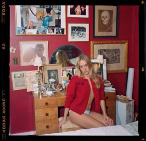 Chloë Sevigny Instagram - #FBF portrait taken in my bedroom I painted blood red after a room in @lhotel_paris. Pic of my father and I hanging behind me. 📸 by @epiclylaterd for @selfservicemagazine 
Hand made cardigan based after one I wore as a child by Eve Korine.
@chloe Resort 2026
“Toallmyknockoffs,knockitoff” 😝