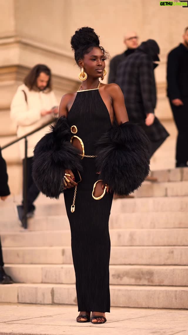 Jodie Turner-Smith - 118.2K Likes - TURNER ON.   @JodieSmith arriving to the @Schiaparelli Spring/Summer 2026 Haute Couture Show at the @PetitPalais_Musee in Paris.  Jodie wears a long dress in black viscose knit with tree bark effect, embellished with irregular cut-outs trimmed with gold metal and a gold jewel chain at the back. Black fur embroidered jacket. Gold hoop earrings adorned with a delicate line of pavé diamonds. « Hand-in-hand » clutch bag in black velvet. Black leather heeled sandals decorated with a signature tape measure embroidery inspired by one of the House’s iconic codes.  Stylist @LuxuryLaw Video @SametGorgozfilms Music @BenBrunnemer  #Schiaparelli
